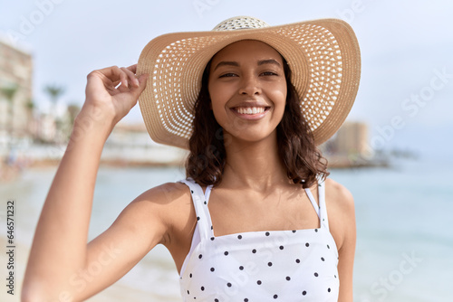 Young african american woman smiling confident wearing summer hat at seaside