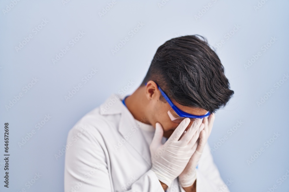 Hispanic man working as scientist with sad expression covering face with hands while crying. depression concept. Hispanic man working as scientist with sad expression covering face with hands while crying. depression concept.