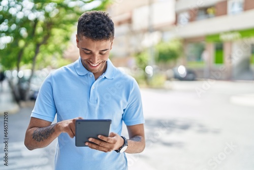 African american man smiling confident using touchpad at street