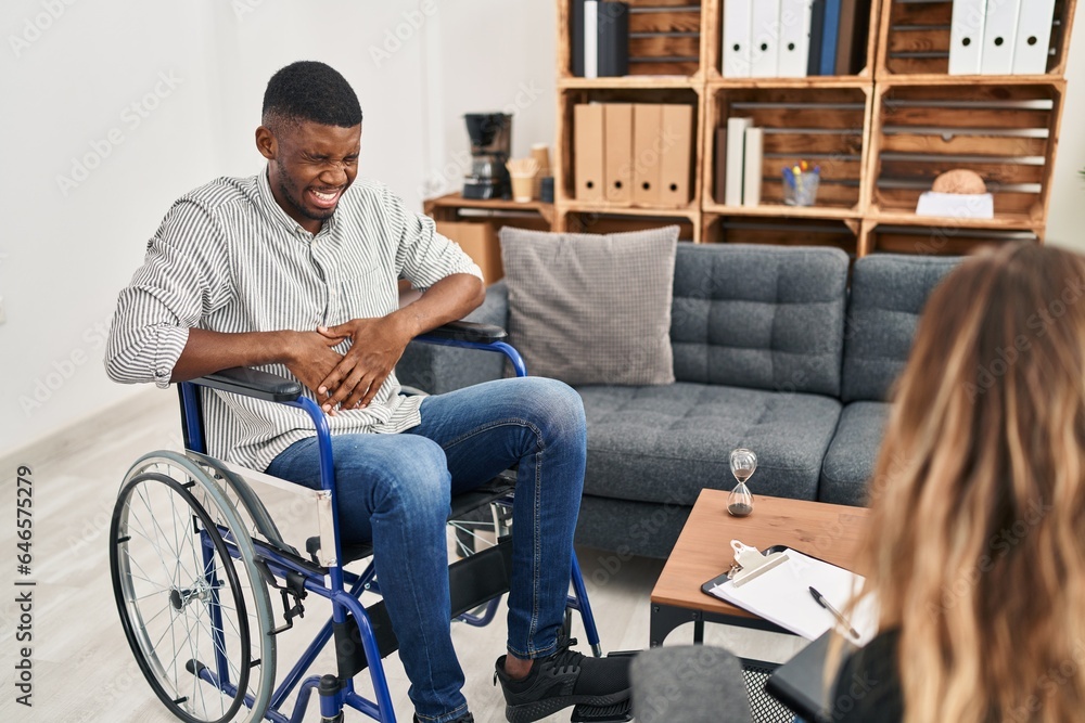 African american man doing therapy sitting on wheelchair with hand on stomach because indigestion, painful illness feeling unwell. ache concept.