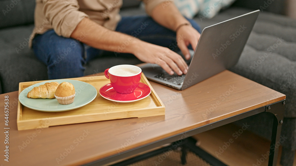 Young hispanic man typing on laptop at home Young hispanic man typing on laptop at home