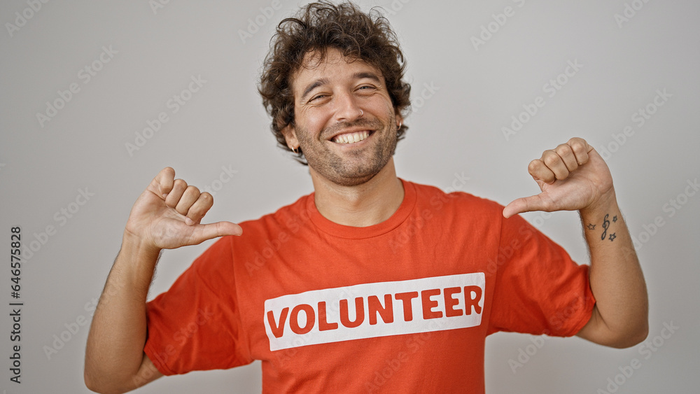 Young hispanic man activist pointing to volunteer uniform smiling over isolated white background Young hispanic man activist pointing to volunteer uniform smiling over isolated white background