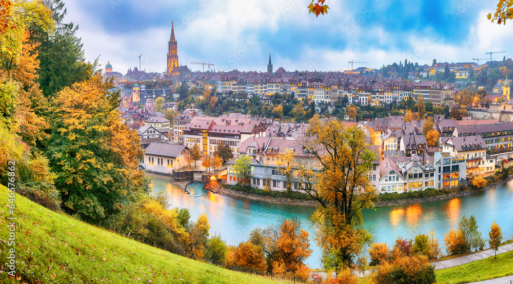 Fabulous autumn view of Bern city on Aare river during evening with Cathedral of Bern on background.