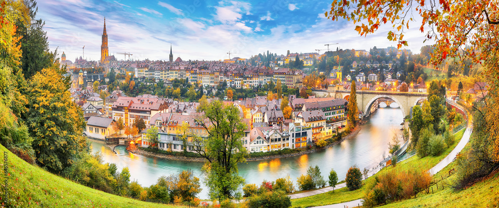 Amazing autumn view of Bern city on  Aare river during evening with Pont de Nydegg bridge , cathedral of Bern and Nydeggkirche - Protestant church.