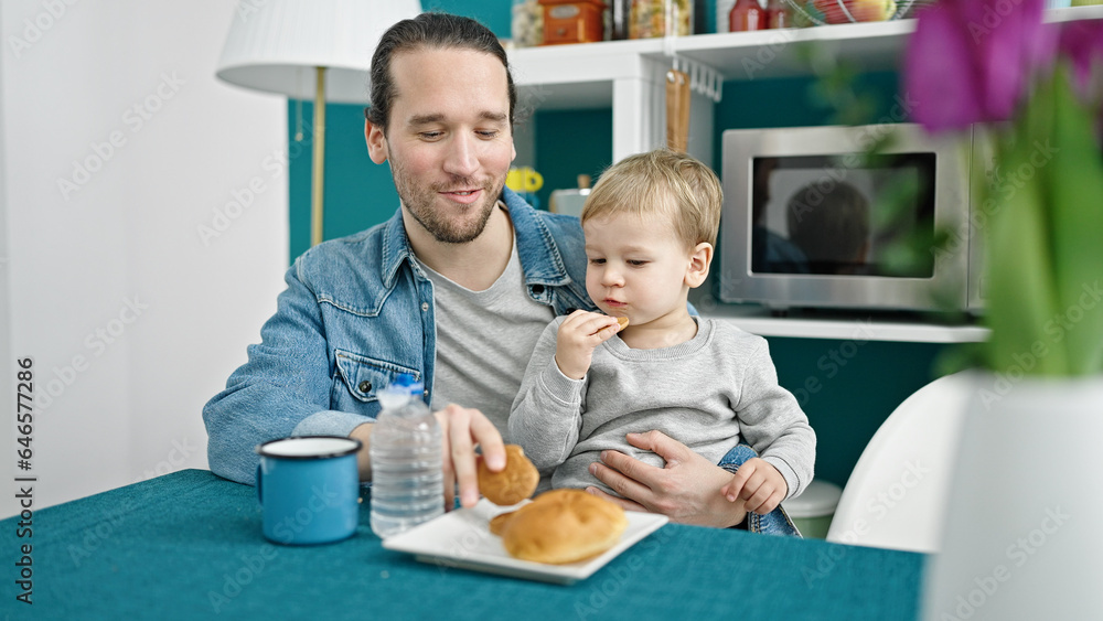 Father and son sitting on table having breakfast at dinning room Father and son sitting on table having breakfast at dinning room