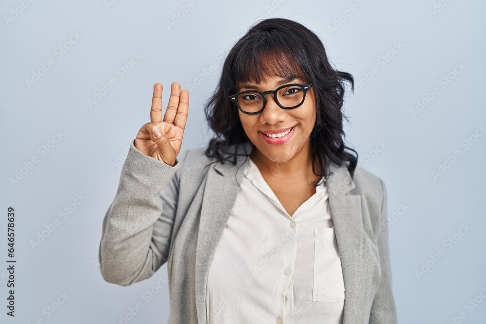 Hispanic woman standing over isolated background showing and pointing up with fingers number three while smiling confident and happy. Hispanic woman standing over isolated background showing and pointing up with fingers number three while smiling confident and happy.