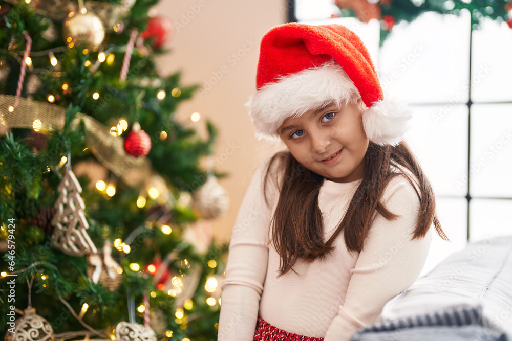 Adorable hispanic girl smiling confident standing by christmas tree at home Adorable hispanic girl smiling confident standing by christmas tree at home