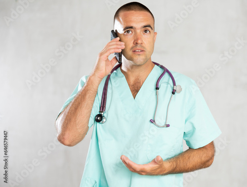 Canvas Print Engaged in direct telephonic conversation, male physician imparts medical insights remotely