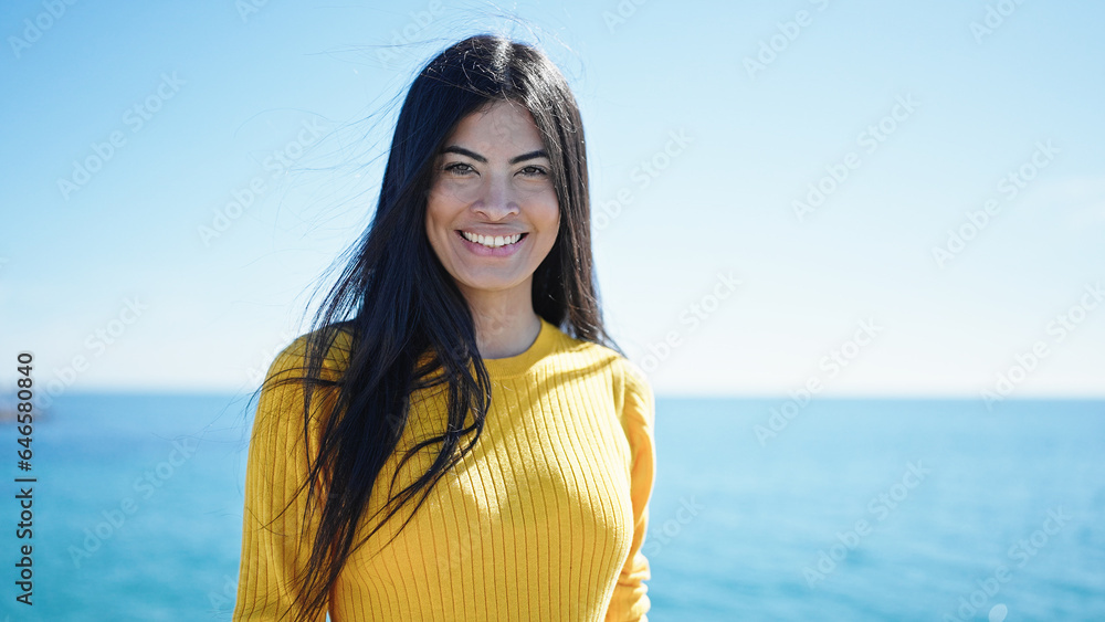 Young beautiful hispanic woman smiling confident standing at seaside Young beautiful hispanic woman smiling confident standing at seaside