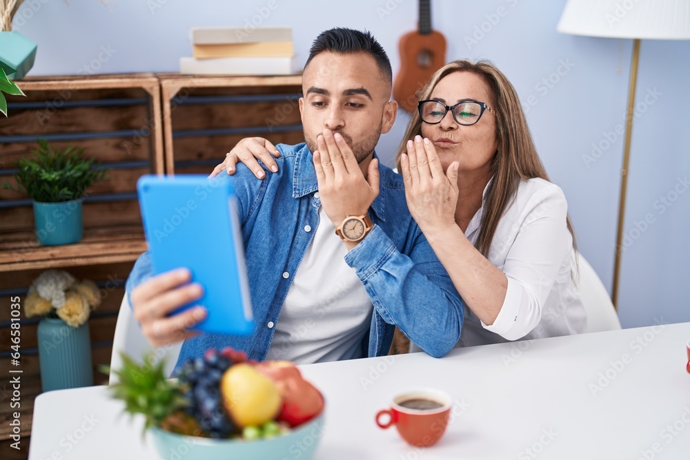 Man and woman mother and son drinking coffee having video call at home Man and woman mother and son drinking coffee having video call at home
