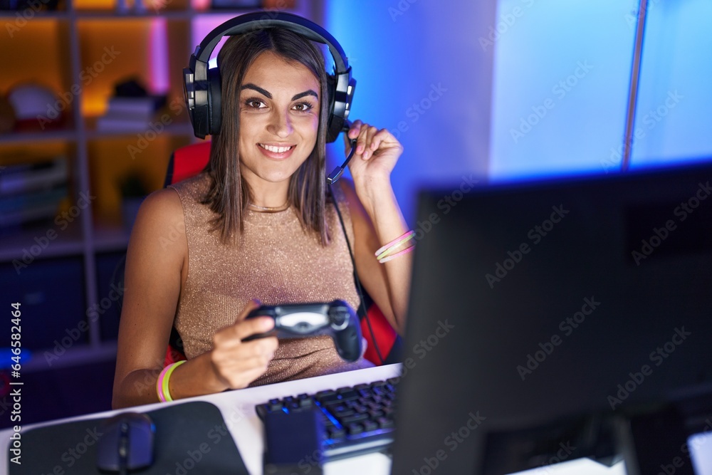 Young beautiful hispanic woman streamer playing video game using joystick at gaming room Young beautiful hispanic woman streamer playing video game using joystick at gaming room