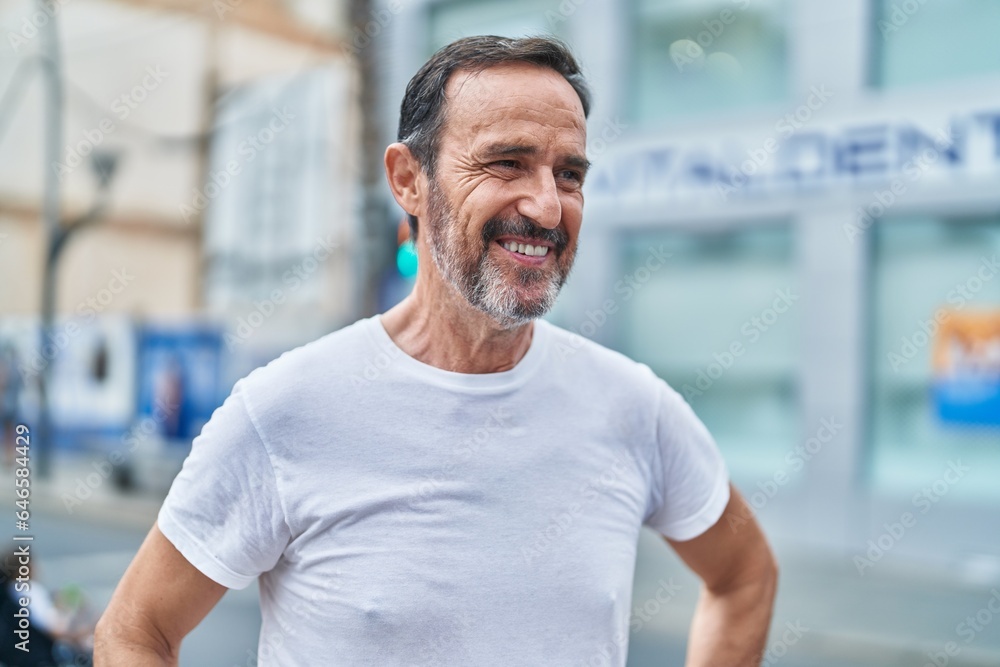 Middle age man smiling confident looking to the side at street