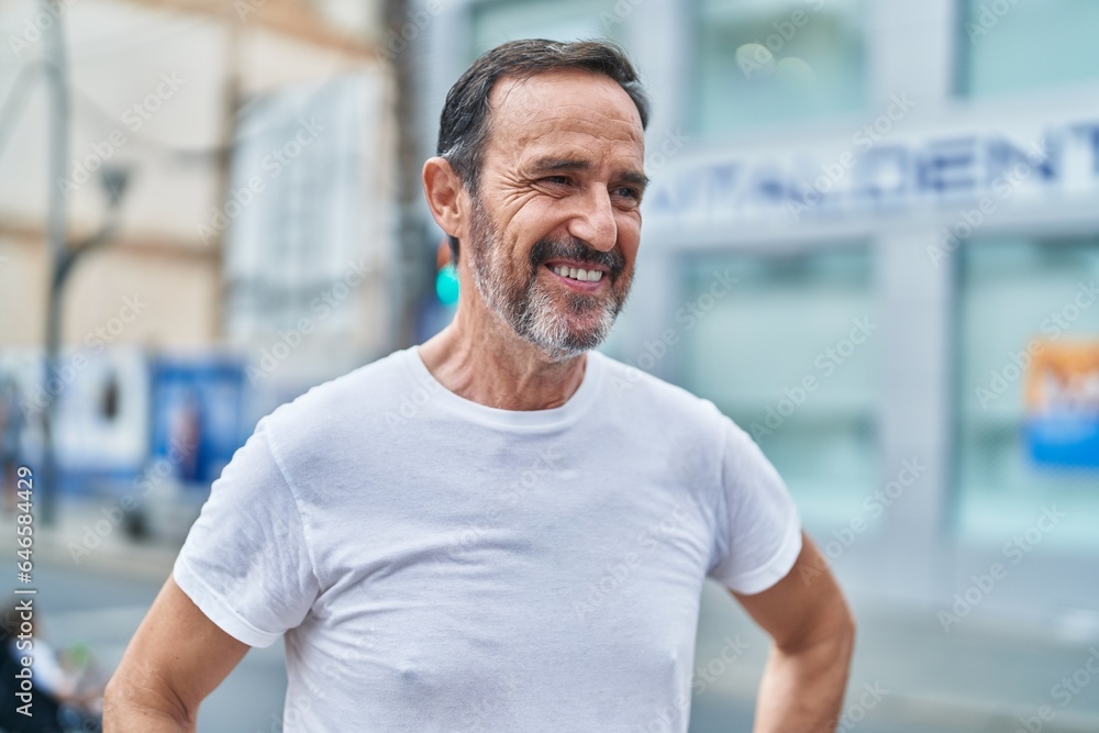 Middle age man smiling confident looking to the side at street Middle age man smiling confident looking to the side at street