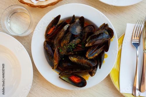 Plate with tasty moules a la marinera braised in savory vegetable sauce. Spanish cuisine..