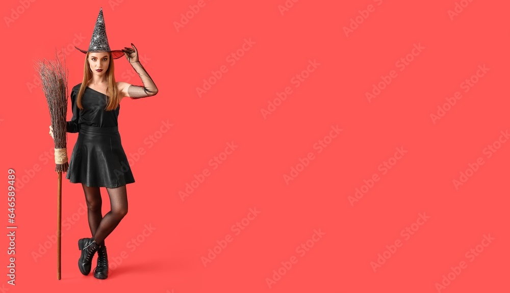 Young witch with broom on red background with space for text