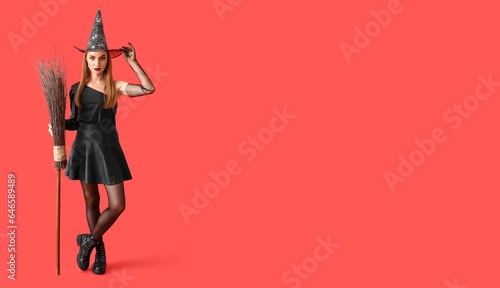 Young witch with broom on red background with space for text