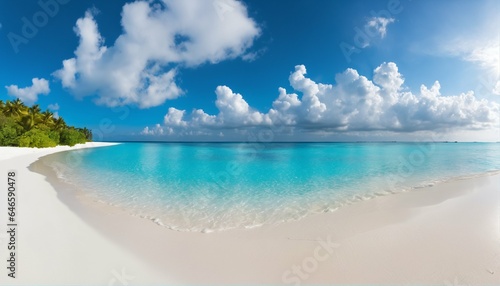 Sandy beach featuring white sand and rolling calm wave of turquoise ocean on sunny day, white clouds in blue sky background