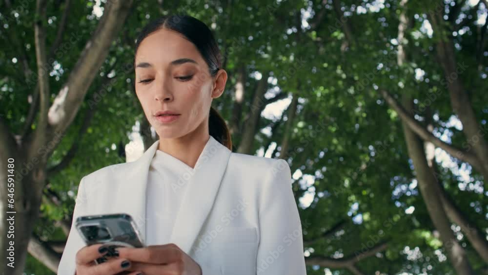 Beautiful lady looking smartphone walking garden close up. Woman scrolling phone Beautiful lady looking smartphone walking garden close up. Woman scrolling phone