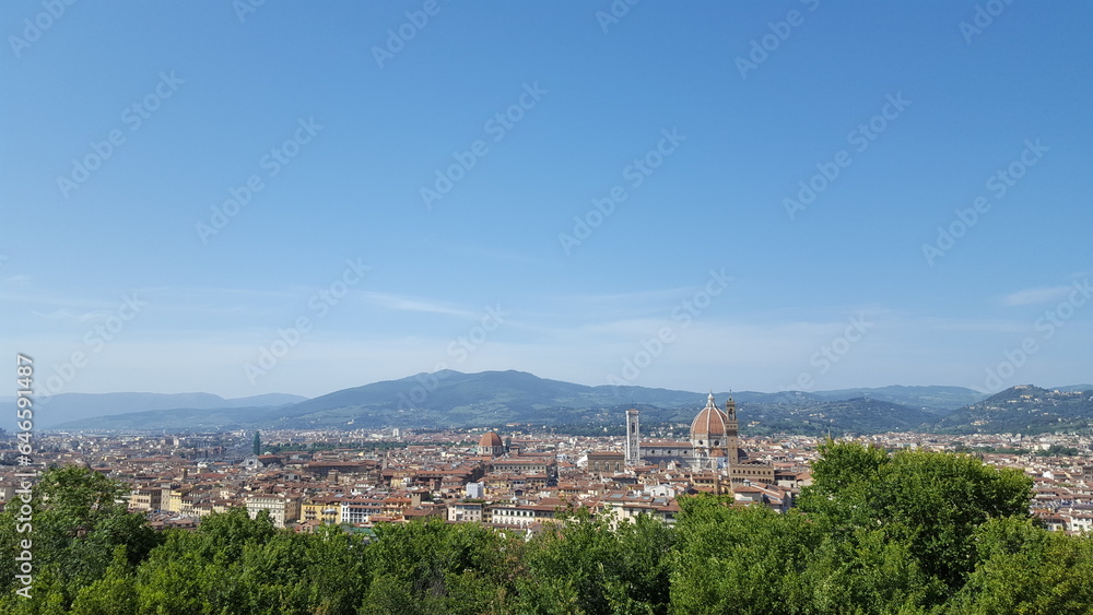 View of Florence, Italy, with majestic mountains looming in the distance, their peaks shrouded in a veil of mist.