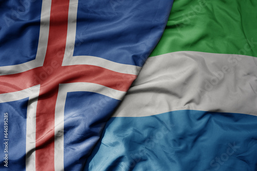 big waving national colorful flag of icelandic and national flag of sierra leone .