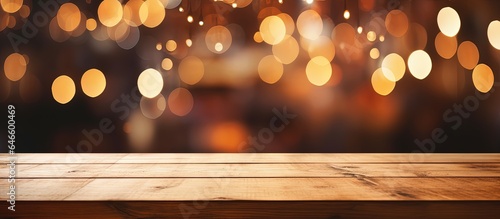 Restaurant background with blurred lights bokeh on an empty wooden table top.