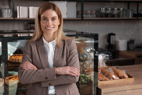 Happy business owner in bakery shop. Space for text