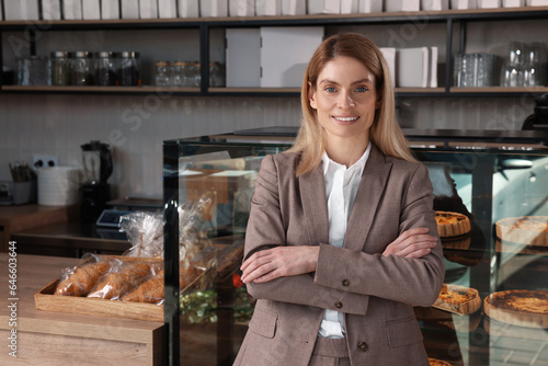 Happy business owner in bakery shop. Space for text