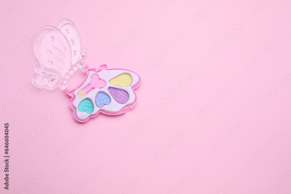 Decorative cosmetics for kids. Eye shadow palette on pink background, top view. Space for text