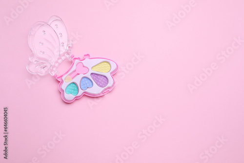 Decorative cosmetics for kids. Eye shadow palette on pink background, top view. Space for text © New Africa