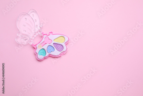 Decorative cosmetics for kids. Eye shadow palette on pink background, top view. Space for text