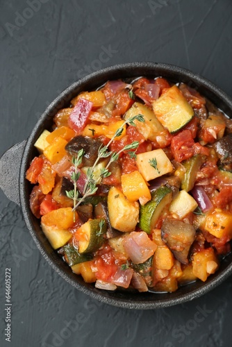 Dish with tasty ratatouille on black table, top view
