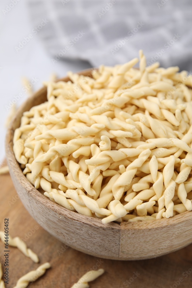 Bowl with uncooked Italian trofie pasta on table, closeup Bowl with uncooked Italian trofie pasta on table, closeup