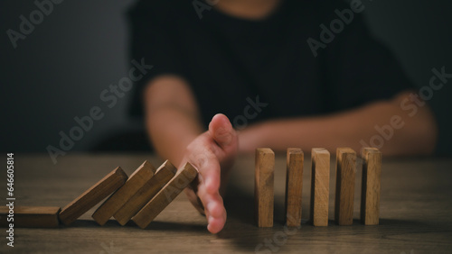 Hand-stopping domino effect. Concept of risk protection, business solution, or successful intervention strategy.