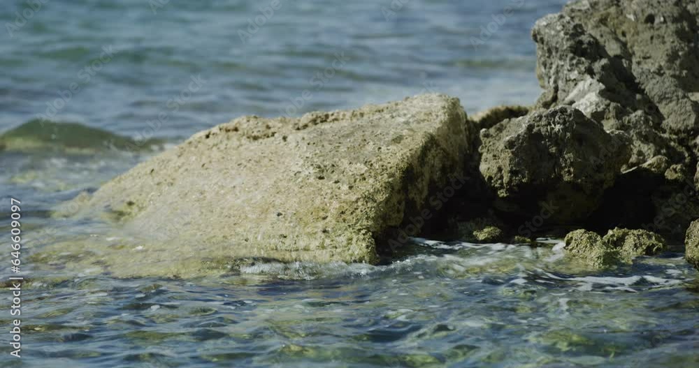 Small waves crashing on rocks in Miami Beach closeup Small waves crashing on rocks in Miami Beach closeup