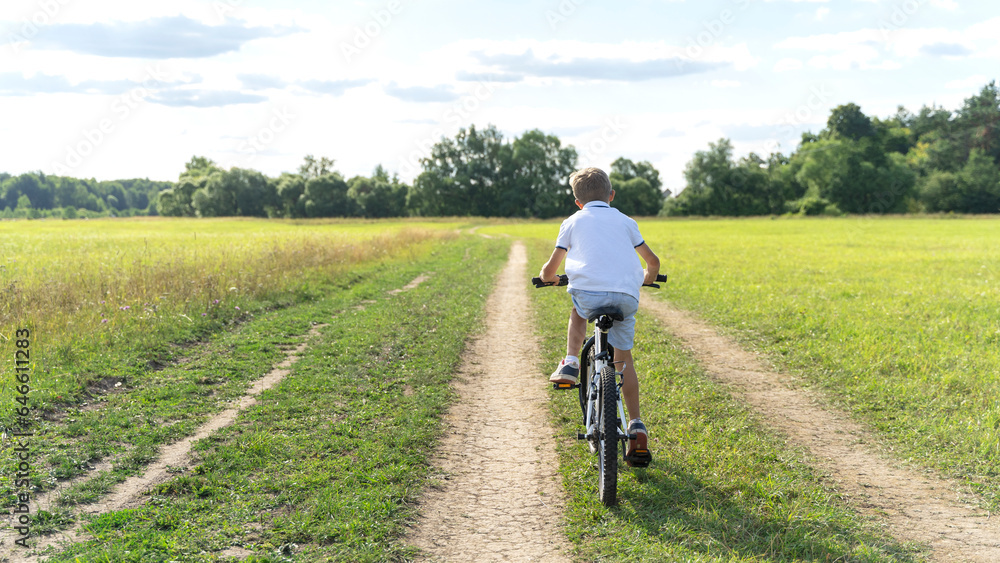 a boy rides a bicycle in nature