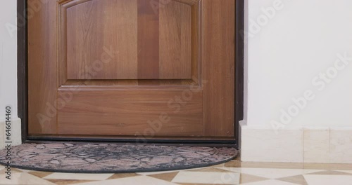 Close-up of hall in house rug lies on floor at open wooden door defiantly slams shut from inside inhospitable host closes the door to uninvited guests, draft breakup, resentment Noisy neighbors 