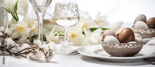 Stylish Easter image with chocolates, candles, and flowers on a white backdrop.