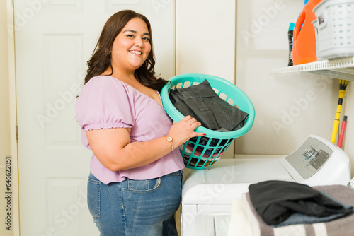 Tableau sur toile Attractive woman smiling doing her laundry and house chores
