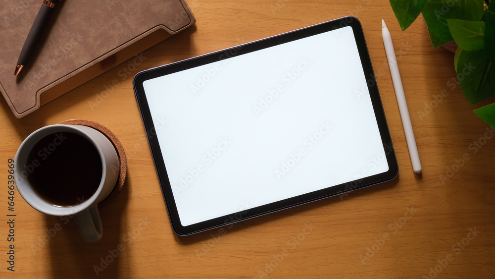 Top view of digital tablet with empty screen, coffee cup, notebook and keyboard on wooden table. Top view of digital tablet with empty screen, coffee cup, notebook and keyboard on wooden table.