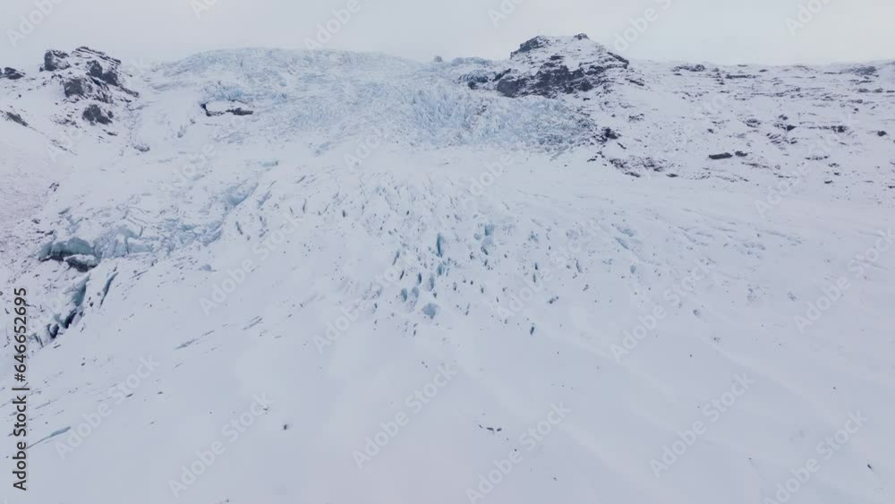 Aerial panoramic view over people hiking towards ice formations in Falljokull glacier covered in snow, Iceland Aerial panoramic view over people hiking towards ice formations in Falljokull glacier covered in snow, Iceland