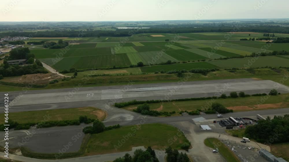 Airport runway number 25. Buildings and vehicles. Fields of trees and crops. Sunset Airport runway number 25. Buildings and vehicles. Fields of trees and crops. Sunset