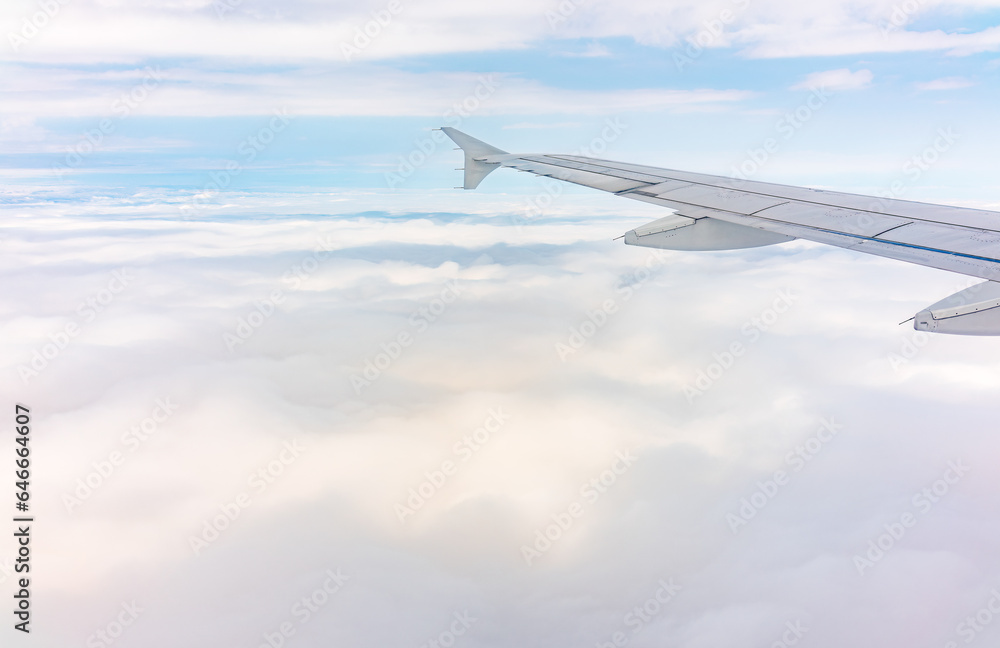Fototapeta premium View from the airplane window at a beautiful cloudy sky and the airplane wing