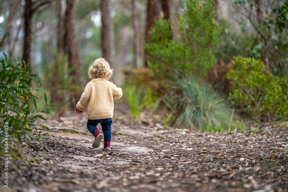 blonde todder walking in a forest on a hike in spring blonde todder walking in a forest on a hike in spring