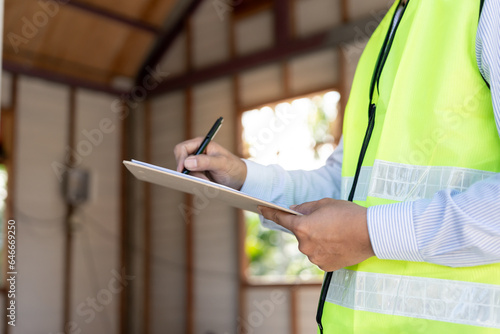 inspector or engineer is inspecting construction and quality assurance new house using a checklist. Engineers or architects or contactor work to build the house before handing it over to the homeowner