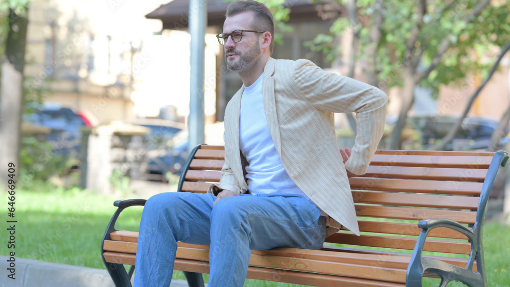 Fototapeta premium Middle Aged Man Sitting Outdoor with Back Pain