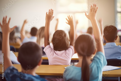 Group of children sitting in classroom, eagerly raising their hands. Perfect for educational and school-related projects.