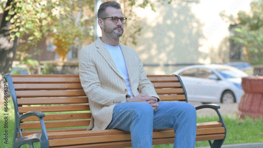Obraz premium Modern Casual Man Sitting Outdoor on Bench