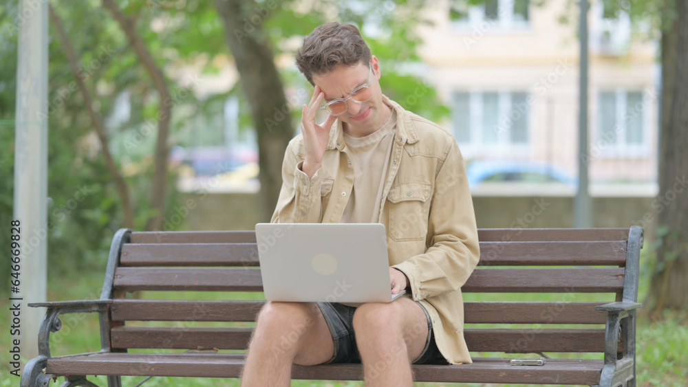 Casual Young Man with Headache Working on Laptop Outdoor Casual Young Man with Headache Working on Laptop Outdoor