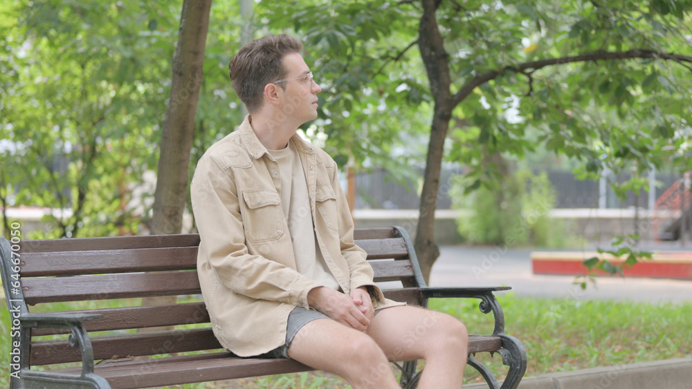 Obraz premium Modern Young Man Coming and Sitting on Bench in Park