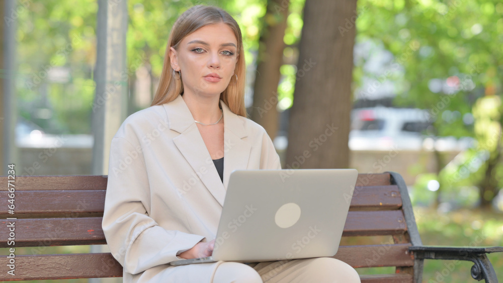 Young Businesswoman Looking at Camera while Working on Laptop Outdoor Young Businesswoman Looking at Camera while Working on Laptop Outdoor